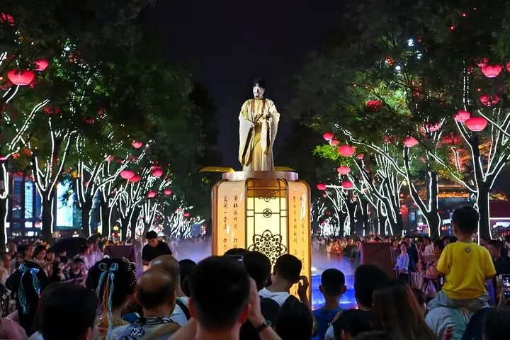 西安大唐不夜城的演员“李白”与游客对诗互动(2024年7月9日摄)。新华社记者邹竞一摄